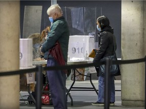 Leisa Lee, right, arrives to cast her vote in an early ballot for next week's municipal elections at the Concordia University building on Ste-Catherine St. on Sunday, October 31, 2021.