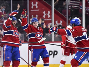 Canadiens' Mathieu Perreault, left, celebrates his third goal of the game with teammates Cole Caufield, center, and Tyler Toffoli during the third period against the Detroit Red Wings at the Bell Center on Saturday, Oct. 23, 2021, in Montreal. .