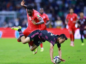 Alphonso Davies of Canada fights for possession with Hirving Lozano of Mexico during the match between Mexico and Canada as part of the 2022 Concacaf FIFA World Cup Qualifier at the Azteca Stadium on October 07, 2021 in Mexico City, Mexico .