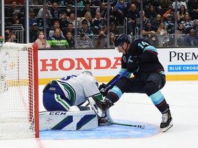 Canucks goalkeeper Thatcher Demko saves Nathan Bastian from the Seattle Kraken in the second period during the Kraken's home opener on Oct. 23, 2021 at the Climate Pledge Arena.