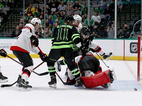 Senators keeper Filip Gustavsson blocks a shot on goal in front of stars forwards Tyler Seguin (91) and Luke Glendening (11) in the first period of Friday's game.