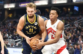 Domantas Sabonis # 11 of the Indiana Pacers and Scottie Barnes # 4 of the Toronto Raptors battle for a fumble during the game at Gainbridge Fieldhouse on October 30, 2021 in Indianapolis, Indiana.