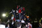 Students climb a play structure in Victoria Park as they celebrate the homecoming of Queen's University in Kingston, Ontario.  on Sunday, October 17, 2021. 