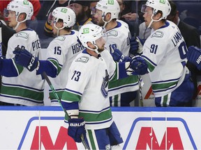 Vancouver Canucks forward Justin Dowling (73) is congratulated on his goal during the first period of the team's NHL hockey game against the Buffalo Sabers on Tuesday, Oct. 19, 2021, in Buffalo, NY.