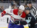Joel Armia and Jaden Schwartz of the Montreal Canadiens of the Seattle Kraken battle for a loose puck during the first period in Seattle on October 26, 2021.