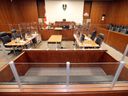 The prisoner's box in the foreground is shown Thursday surrounded by Plexiglas in one of the courtrooms of the High Court of Justice in Windsor.  Plexiglass also surrounds the judge's bench, the tables of the defense and Crown attorneys, as well as the court clerk and court reporter and the witness stand.