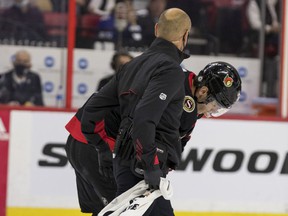 Senators center Shane Pinto (12) is helped off the ice during the first period of Thursday's game against the Sharks with what initially appeared to be a shoulder injury.  He came back for a shift in the second period, but didn't play again after that.