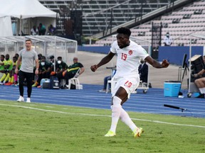 Alphonso Davies of Canada crosses a ball against Jamaica in a FIFA World Cup qualifying match in Kingston, Jamaica on October 10, 2021.