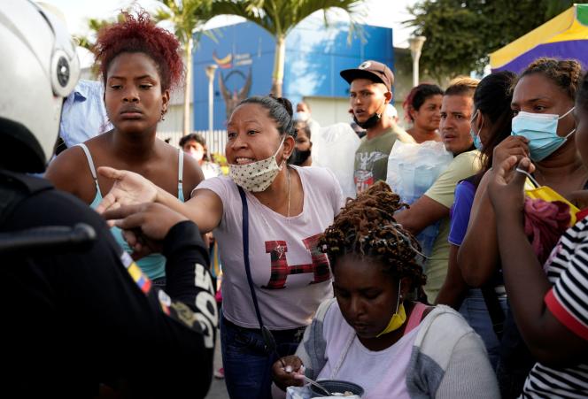 Relatives of prisoners speak to police in front of the prison in Guayaquil, Ecuador, on September 30, 2021.