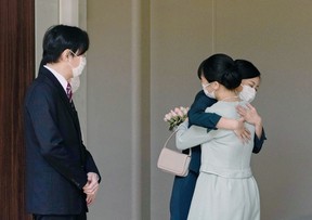 Princess Mako of Japan (right) hugs her sister, Princess Kako (second right) before leaving their home on Akasaka Estate in Tokyo on October 26, 2021 (STR / JAPAN POOL / AFP Photo via Getty Images).