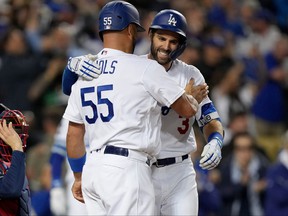 Los Angeles Dodgers first baseman Albert Pujols, left, celebrates after scoring on a two-run home run by left fielder Chris Taylor in the fifth inning against the Atlanta Braves during Game 5 of the 2021 NLCS at Dodger Stadium in Los Angeles, California.  October 21, 2021.