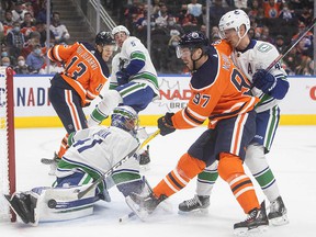 Vancouver Canucks goalkeeper Jaroslav Halak (41) saves Connor McDavid (97) from Edmonton Oilers while Elias Pettersson (40) defends during the NHL preseason second period in Edmonton on Thursday, October 7.