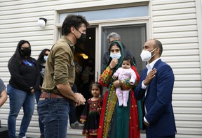 Prime Minister Justin Trudeau greets Obaidullah Rahimi, right, his wife Arezoo and their daughters Hawa, 2 months, and Ayat, 3, in Ottawa on Saturday, October 9, 2021. Obaidullah Rahimi worked at the Embassy from Canada in Afghanistan;  her family is one of 22 Afghan families resettled in the Ottawa area.  THE CANADIAN PRESS /
