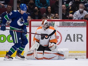 Philadelphia Flyers goalkeeper Martin Jones saves Vancouver Canucks' Vasily Podkolzin in front of him during the first period.