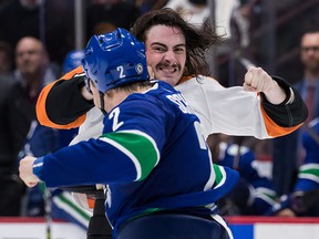 Zack MacEwen of the Philadelphia Flyers and Luke Schenn of the Vancouver Canucks fight during the second period.  MacEwen received an extra minor penalty for grabbing the visor.