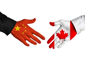 Chinese and Canadian leaders shaking hands on a deal agreement