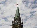 The Canadian flag flies at half mast at the Peace Tower on Parliament Hill in recognition of the discovery of unmarked indigenous graves in residential schools on Canada Day, July 1, 2021. 
