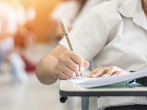 Exam with school student having educational test, thinking hard, writing answer in classroom for admission to university education and world literacy day concept