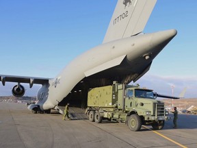 The Canadian Forces Reverse Osmosis Water Purification team unloads from a military transport aircraft, which was requested after officials in Nunavut said laboratory results confirmed fuel had entered their water supply in Iqaluit, on Saturday, October 23, 2021.