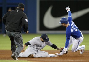 New York Yankee Gleyber Torres # 25 of the New York Yankees loses the tag to Corey Dickerson of the Jays at the Rogers Center on Thursday.  fake images