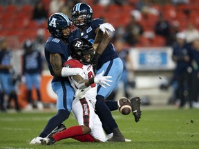 Ottawa Redblacks wide receiver RJ Harris (84) drops the ball, while Toronto Argonauts defensive back Chris Edwards (6) and Argonauts linebacker Dexter McCoil (26) remain up close during the first half of CFL football action in Toronto on October 6, 2021.