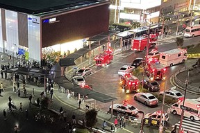 This aerial image shows firefighters and rescuers gathered in front of Kokuryo Station on the Keio Line in the western Tokyo city of Chofu on October 31, 2021, after a man injured at least 10 people with a knife and a fire attack on a train.