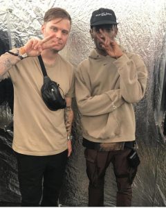 Musician Travis Scott pictured in a beige Nike hoodie