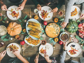 Friends eating at Thanksgiving table with vegetarian meals