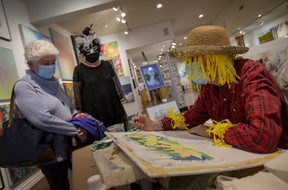 Artist Jude Quick offers a watercolors demonstration while dressing up as a scarecrow for Halloween, at the Nancy Johns Gallery and Framing on October 30, 2021.