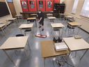 In this Feb. 5, 2021, file photo, Cory Gagnon, a Kennedy Collegiate janitor, cleans a classroom at the high school.  Local boards canceled this year's EQAO testing for grades 10.