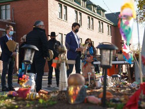 In this photo provided by the Office of the Prime Minister of Canada, Canadian Prime Minister Justin Trudeau (R) and Canadian Indigenous Services Minister Marc Miller (L) lay flowers at a memorial outside the Kamloops Indigenous Residential School in Kamloops, United Kingdom Columbia on October 18, 2021. - Canadian Prime Minister Justin Trudeau visited the indigenous community of Kamloops where the remains of 215 children were found in May in a former residential school.  (Photo by Adam Scotti / Office of the Prime Minister of Canada / AFP) / RESTRICTED TO EDITORIAL USE - MANDATORY CREDIT “AFP PHOTO / Adam SCOTTI / Office of the Prime Minister of Canada” - NO MARKETING - NO ADVERTISING CAMPAIGNS - DISTRIBUTED AS A SERVICE TO CUSTOMERS