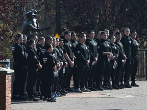 Participants in the 2021 Fallen Officers Commemorative Race pose for a photo in front of fallen officer Cst.  Statue of Ezio Faraone in the park of the same name in Edmonton, October 7, 2021. Ed Kaiser / Postmedia