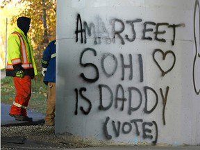 City workers remove some municipal election graffiti under Quesnell Bridge in Edmonton on Thursday, Oct. 7, 2021. (PHOTO BY LARRY WONG / POSTMEDIA)