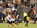 Montreal Alouettes wide receiver Eugene Lewis hits a touchdown reception to give his team the lead late in the second half against the Hamilton Tiger-Cats in Hamilton, Ontario, on October 2, 2021.