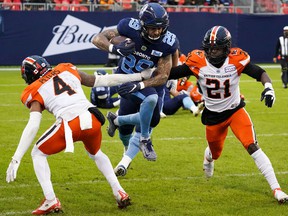 Toronto Argonauts running back DJ Foster (29) avoids a tackle by BC Lions defensive back Garry Peters (4) and Jordan Williams (21) on Saturday at BMO Field.
