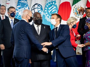 US President Joe Biden shakes hands with French President Emmanuel Macron as DRC President Felix Tshisekedi watches during a family photo session on the sidelines of the G20 summit in La Nuvola in Rome, Italy, on October 30, 2021.