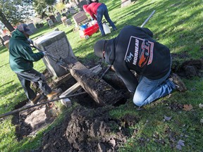 Ray Morneau (left) and his nephew Ray Morneau of Hallmark Memorial Co. removed a pillar from a memorial buried from the ground in Windsor Grove Cemetery on Tuesday, October 26, 2021. The pillar was found by members of the county branch of Essex of the Genealogical Society of Ontario.  .