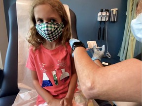 Lydia Melo, 7, is inoculated with one of two reduced doses of the Pfizer BioNTech vaccine during a trial at Duke University in Durham, North Carolina, on September 28, 2021.
