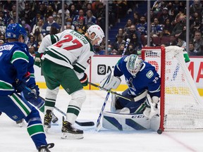 Vancouver Canucks goalkeeper Thatcher Demko (35) stops Minnesota Wild's Nick Bjugstad (27) during the first period of an NHL hockey game in Vancouver, Tuesday, Oct. 26, 2021.