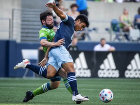 Vancouver Whitecaps midfielder Michael Baldisimo, right, and Seattle Sounders midfielder Joao Paulo, left, battle for possession in the first half of an MLS soccer game Saturday, June 26. 2021 in Seattle.