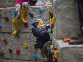 Theodore Sekela, 4, of Natural Pathways Forest and Nature School climbs the stone wall of the new Enbridge Natural Playground at the Holiday Beach Conservation Area in Amherstburg, Wednesday, Oct. 27, 2021.