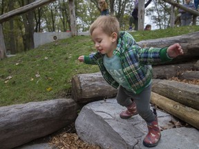 Milo Kissel, 2, of Natural Pathways Forest and Nature School, leaps down the stone steps of the new Enbridge Natural Playground at the Holiday Beach Conservation Area in Amherstburg, Wednesday, Oct. 27, 2021.