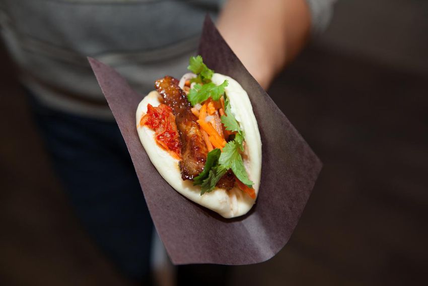 Seared pork belly with Sriracha-sambal sauce, pickled daikon and coriander on a steamed bun from Noodle Bao's stand.
