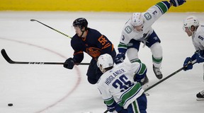 Edmonton Oilers Kailer Yamamoto (56) battle Vancouver Canucks' Nils Hoglander (36), Jack Rathbone (3) and Brock Boeser (6) during the first period of NHL action at Rogers Place in Edmonton on Saturday the 8th. May 2021. Photo by David Bloom