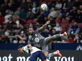 Minnesota United's Romain Metanire, above, falls to Vancouver Whitecaps' Javain Brown as they compete for the ball during the first half of an MLS soccer game in Vancouver, Wednesday, Oct. 27, 2021.