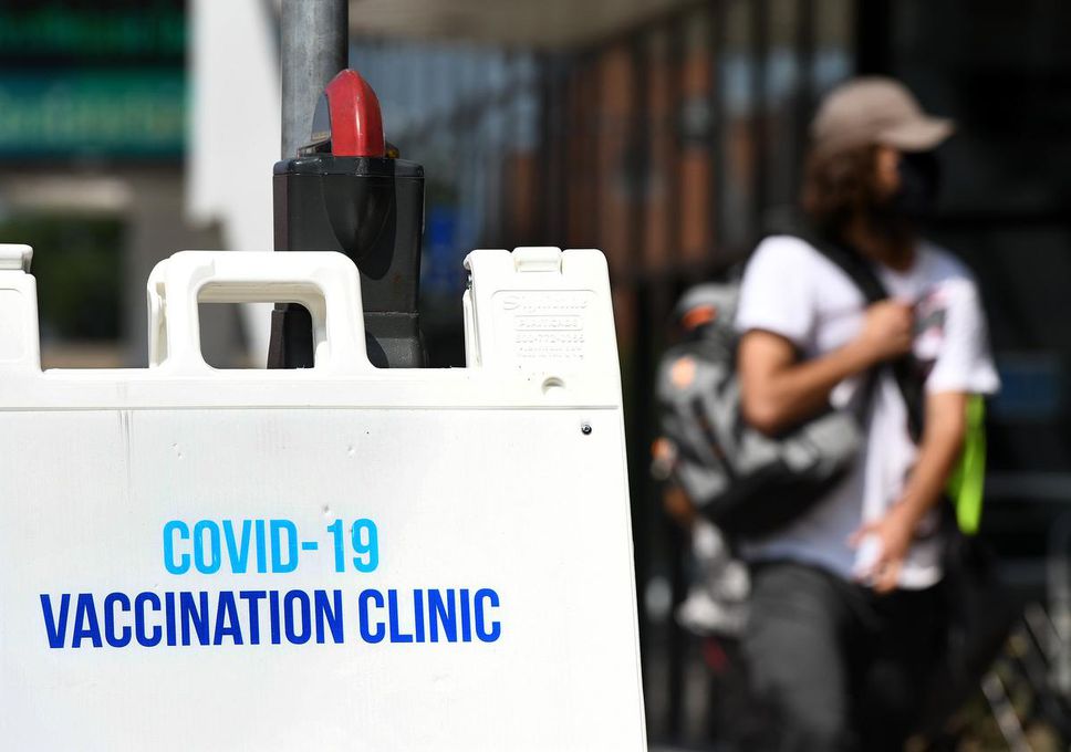 A pedestrian passes a COVID-19 vaccination clinic at the First Ontario Center in downtown Hamilton in August.