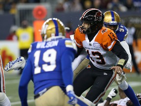BC Lions quarterback Mike Reilly (center) is downed by S Brandon Alexander (right) after throwing the ball at IG Field in Winnipeg on Saturday, October 23, 2021. KEVIN KING / Winnipeg Sun / Postmedia Network