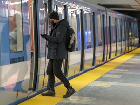 The masked Metro passenger boards a train in Montreal on Wednesday, January 27, 2021.