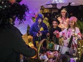 On a rainy Halloween night in Montreal on Sunday, from left: Eliott Seivewright, Alec Seivewright, Emma Wyatt and Eva Langlois receive candy at a Montreal West home.
