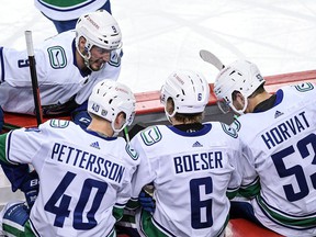 Vancouver Canucks' JT Miller, Elias Pettersson, Brock Boeser and Bo Horvat discuss strategy during an NHL game on February 17.